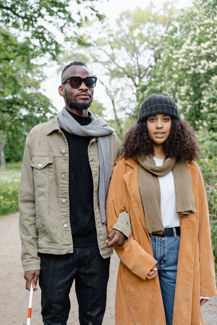 A couple walking outdoors, highlighting inclusivity and support. Scenic greenery surrounds them.